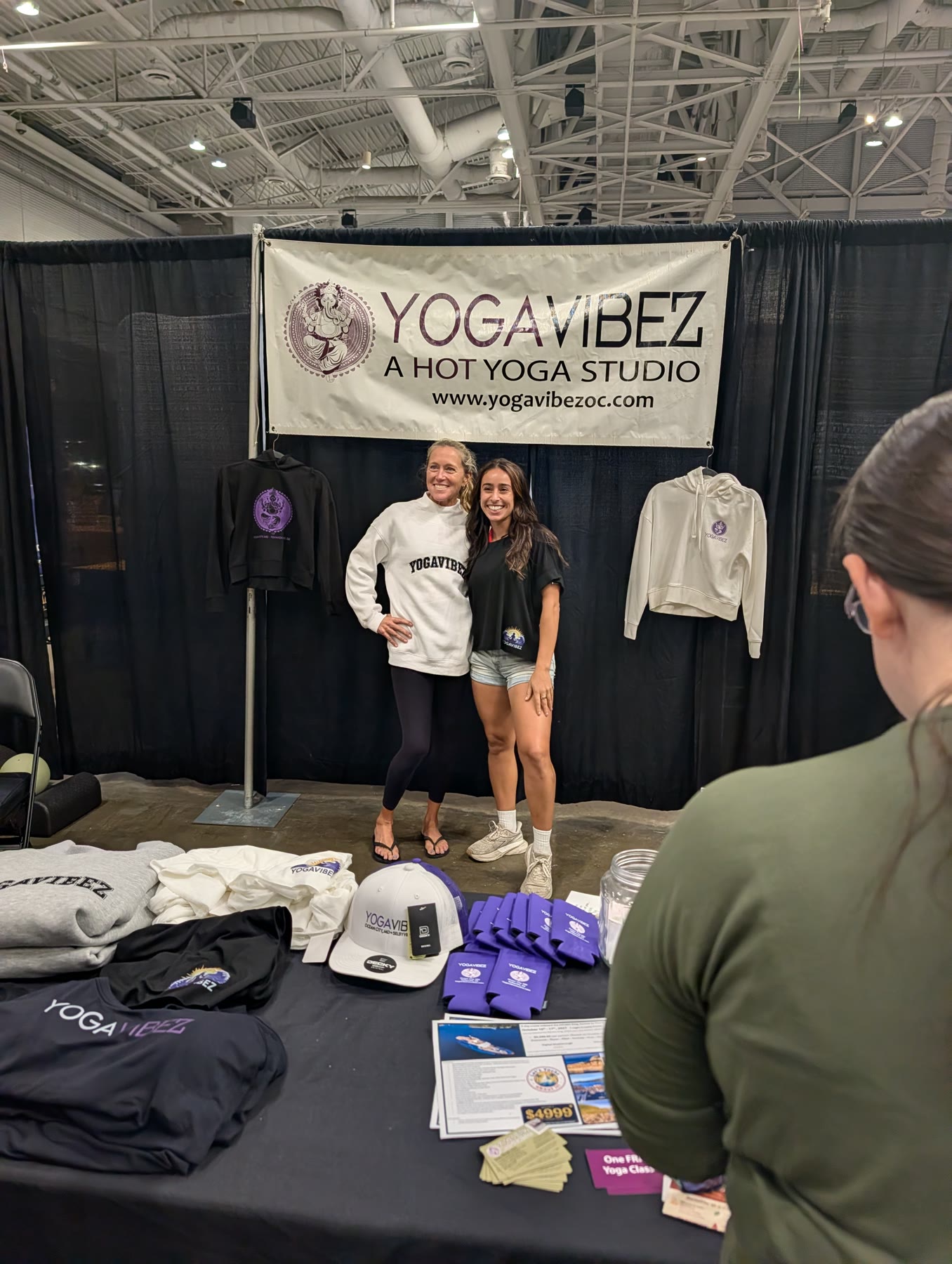 Two women from YogaVibez hot yoga studio at their booth