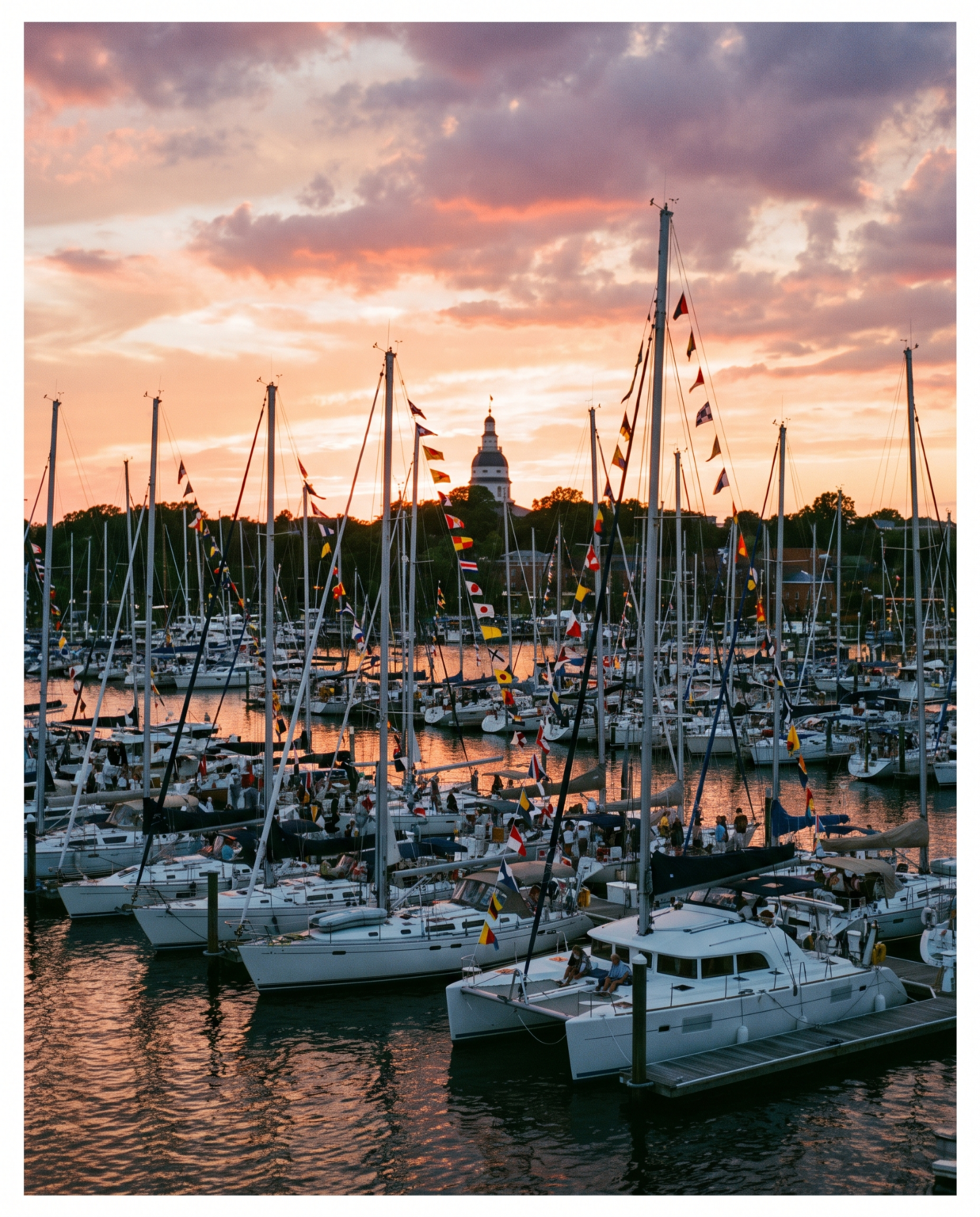 Sailboat masts and signal flags at sunset in Annapolis harbor