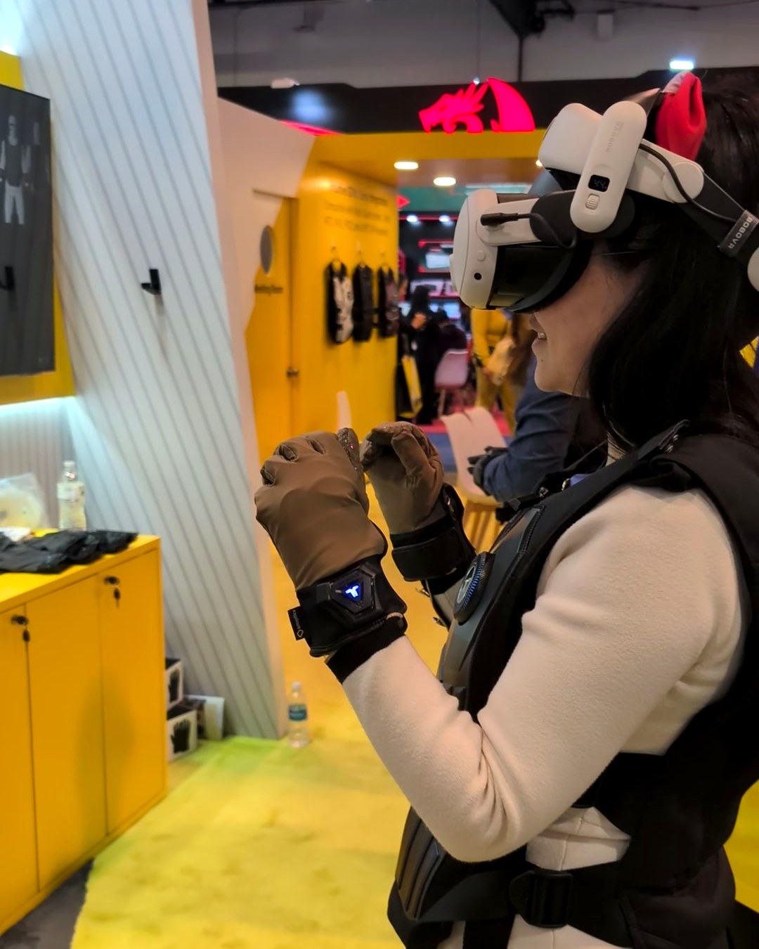 Visitor wearing a bHaptics TactSuit vest, haptic gloves and a VR headset at CES 2025