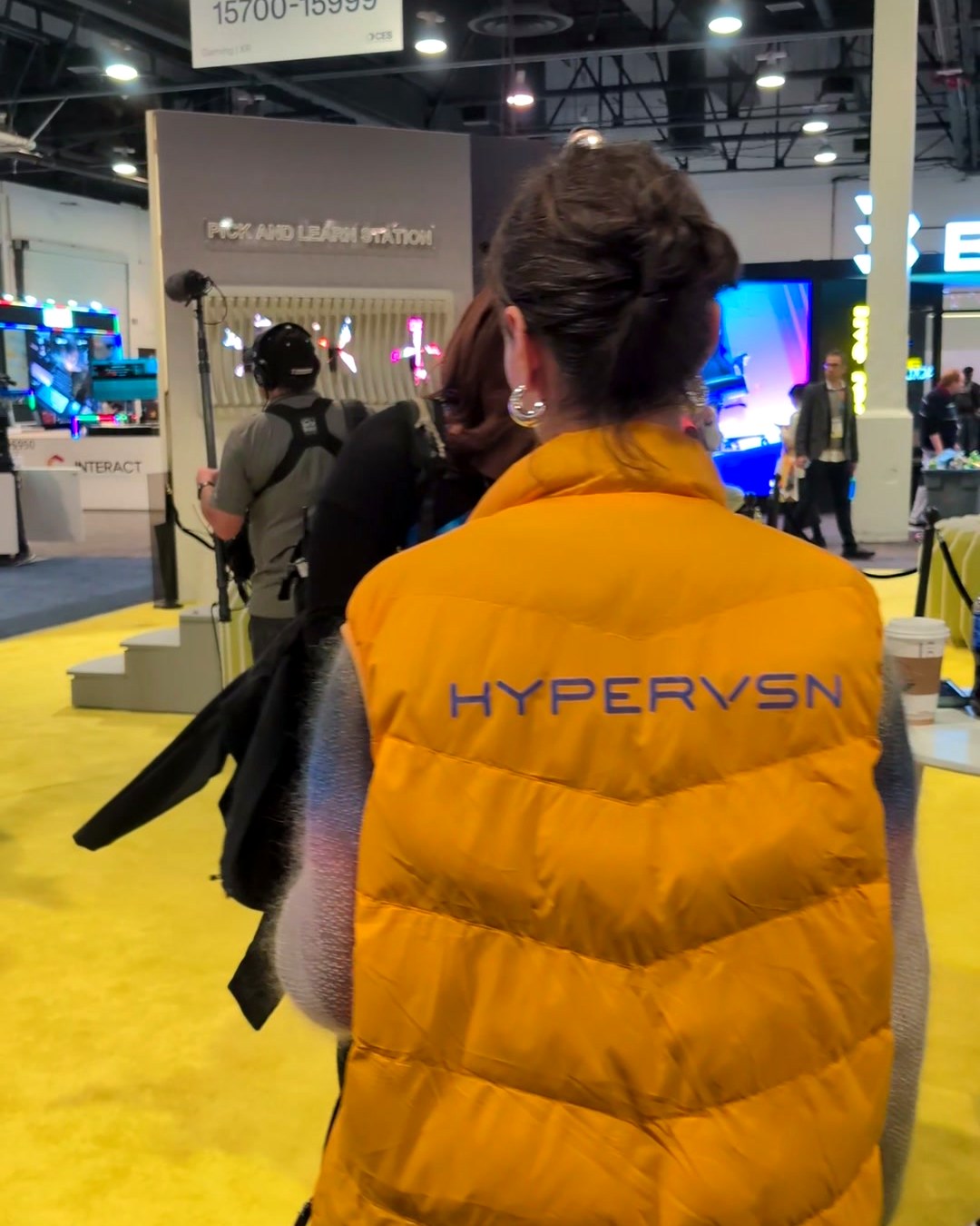 HYPERVSN team member in a branded yellow vest at the booth, CES 2025