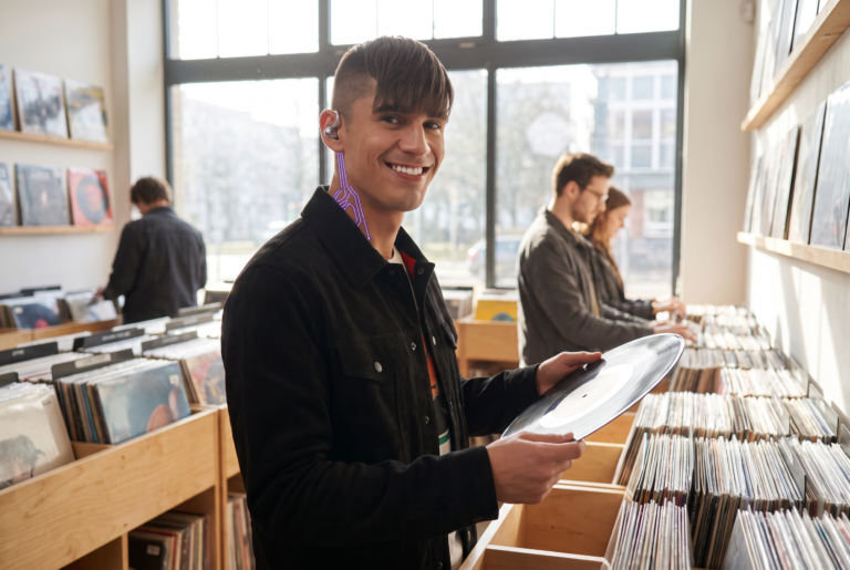Jett Rivera holding up a vinyl record in a record shop