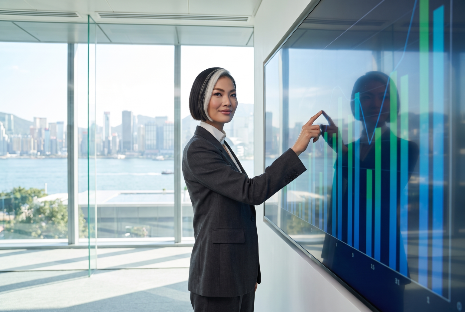 Vivian Sterling, Citywide.TV's AI-generated business host, presenting charts on a wall screen in a glass office above the waterfront