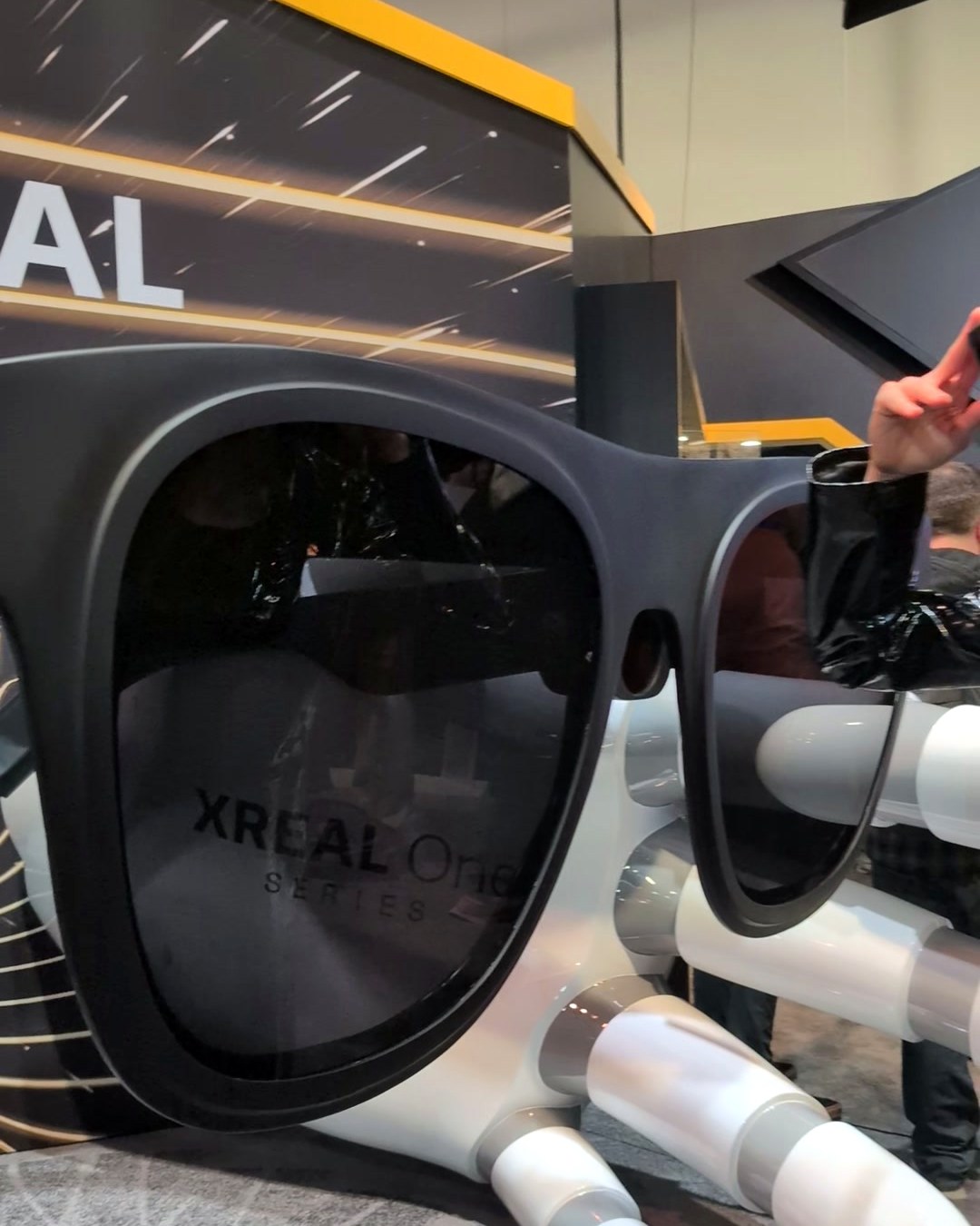 Giant XREAL One series glasses sculpture held by a robotic hand at the XREAL booth at CES 2025