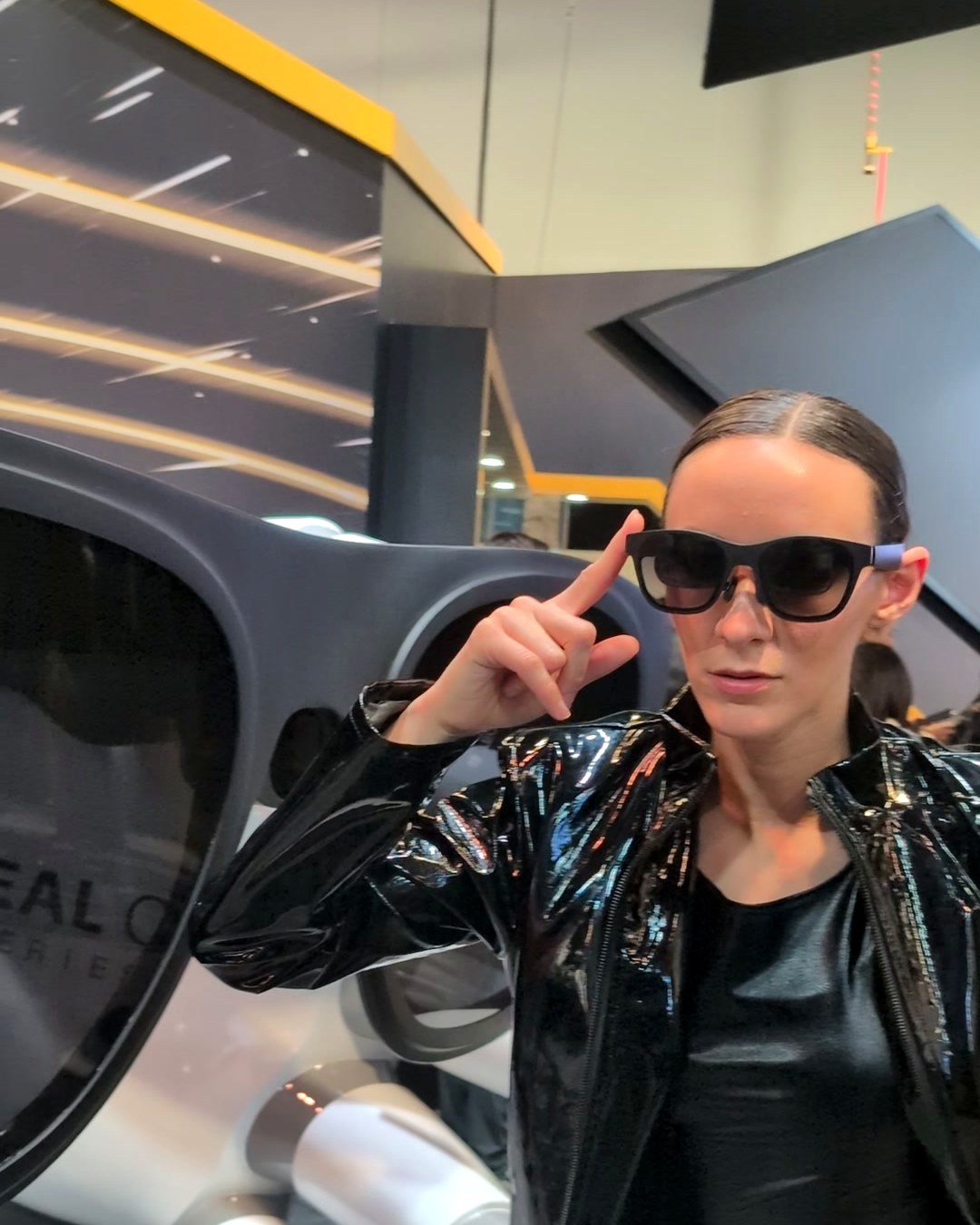 Performer wearing XREAL glasses in front of the giant XREAL One sculpture at CES 2025